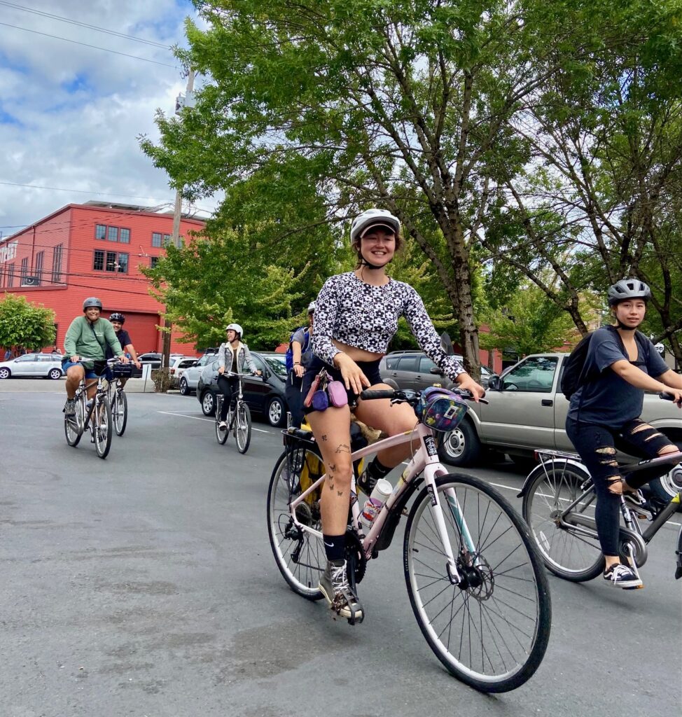bicyclists ride into the streets of portland with smiles