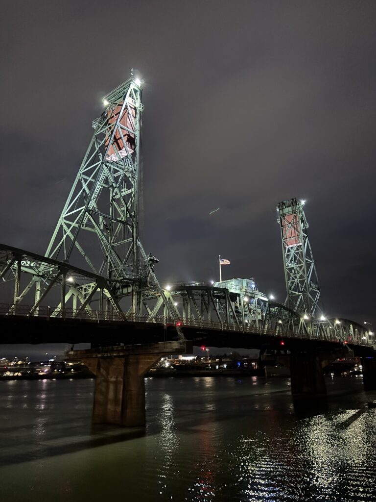the green metal lift of the Hawthorne bridge is lit up spookily at night